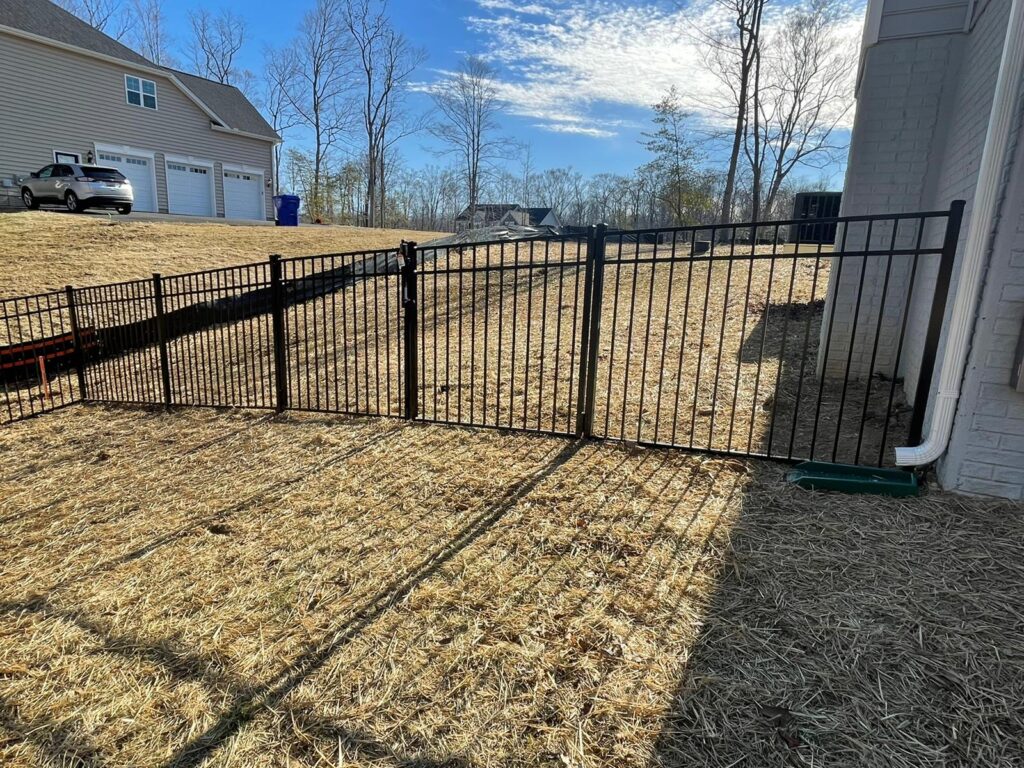 Black aluminum fence on a freshly graded backyard