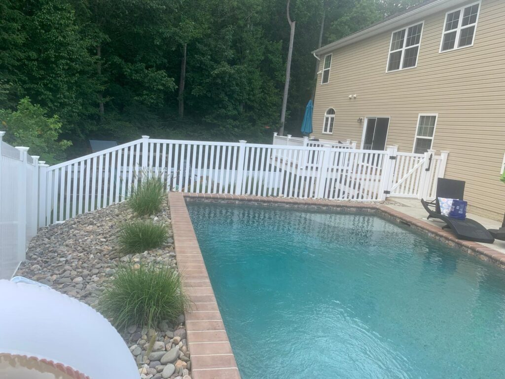 White vinyl fence around an in-ground pool