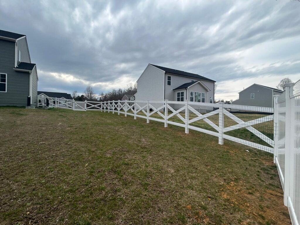 White vinyl ranch rail fence along a backyard