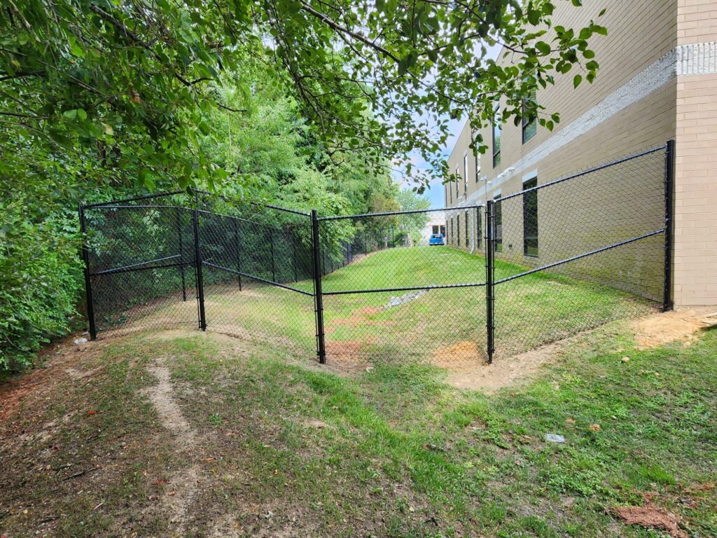 Black chain link side yard fence on a slope