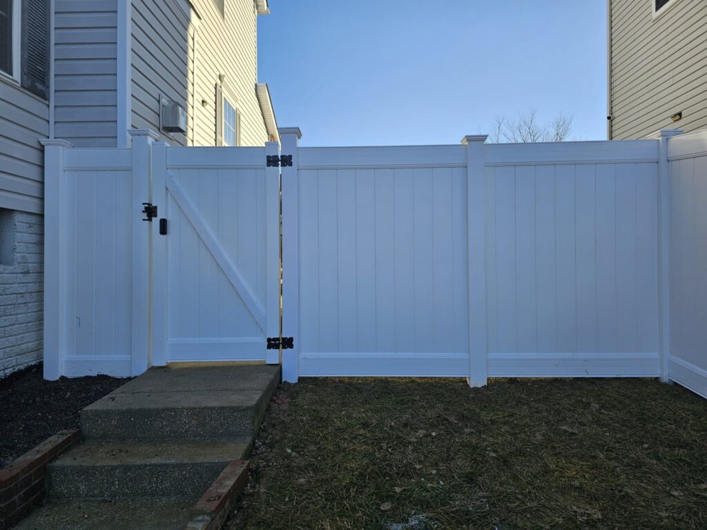 White vinyl privacy fence and walk gate by a back step