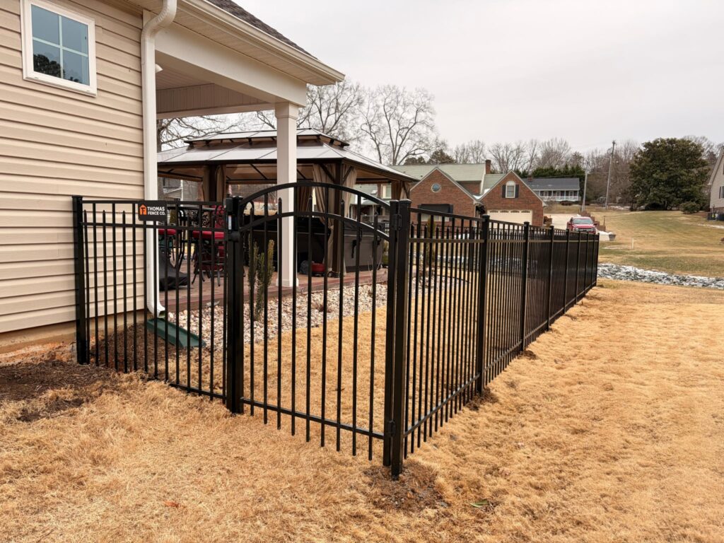 Black aluminum fence and gate off a covered patio