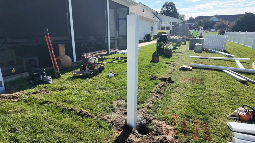 New white vinyl fence post set in a backyard